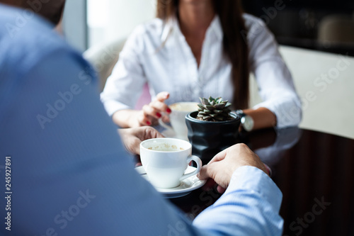 Flirting in a cafe. Beautiful loving couple sitting in a cafe enjoying in coffee and conversation. Love and romance