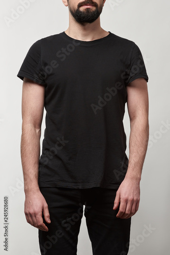 partial view of bearded man in black t-shirt with copy space isolated on grey