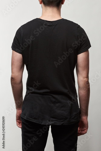 back view of man in black t-shirt with copy space isolated on grey