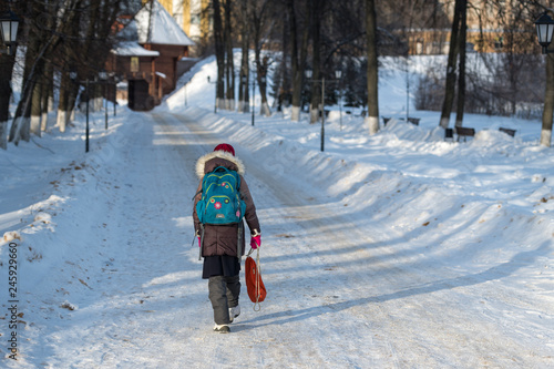 girl with backpack goes from school in winter