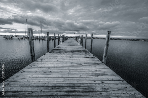 Black And Coastal Landscape. Long diminishing wooden pier on the Michigan coast.