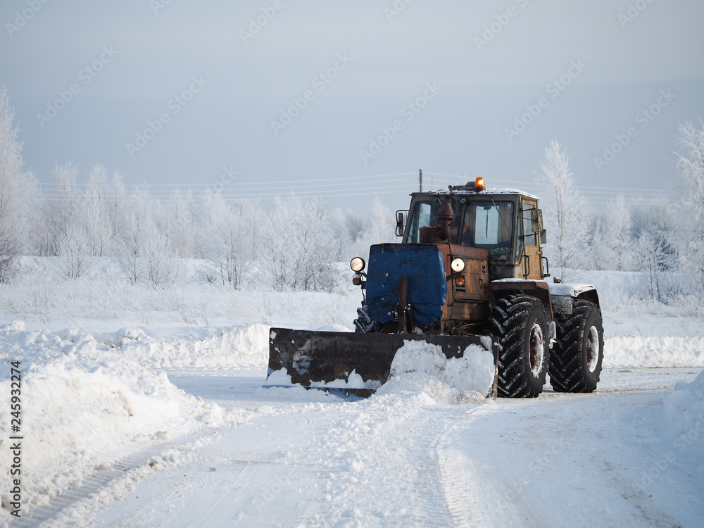 Tver region. Sonkovsky district. Russia. 28 January 2019. Clearing snow from the road. Tractor grader clears snow from the road. Tver region. Sonkovsky district. Russia. 28 January 2019. Clearing snow from the road. Tractor grader clears snow from the road.