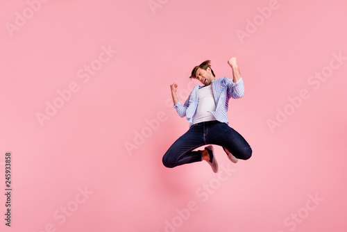 Full length body size photo of jumping high crazy he his him handsome oh no expression fall down epic lost break down wearing casual jeans checkered plaid shirt isolated on rose background photo