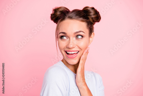Close-up portrait of her she nice cute lovely attractive winsome adorable cheerful cheery girl with buns touching cheek isolated over pink pastel background