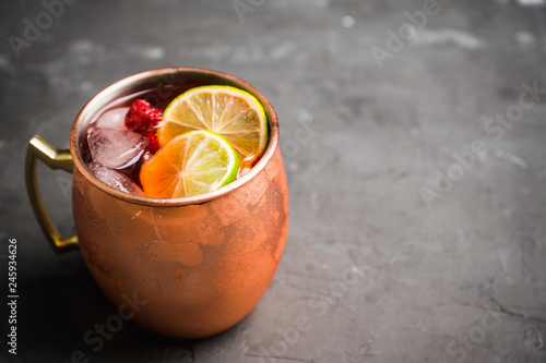 Photography Sweet moscow mule with lime and raspberry in copper mug on the rustic background