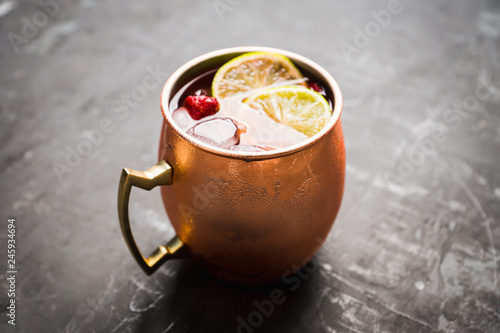 Photography Sweet moscow mule with lime and raspberry in copper mug on the rustic background
