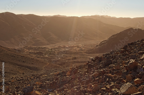 Valley with small village between high mountains. View from Mount Sinai (Mount Horeb, Gabal Musa). Scenic winter morning. Sinai Peninsula of Egypt photo