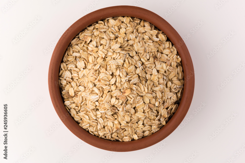 Dry rolled oatmeal in bowl isolated on white background. Top view Dry rolled oatmeal in bowl isolated on white background. Top view
