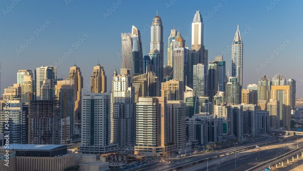 Dubai Marina towers during sunset aerial timelapse, United Arab Emirates. Sun reflected from skyscrapers with long shadows. Top view from JLT with traffic on the road Dubai Marina towers during sunset aerial timelapse, United Arab Emirates. Sun reflected from skyscrapers with long shadows. Top view from JLT with traffic on the road