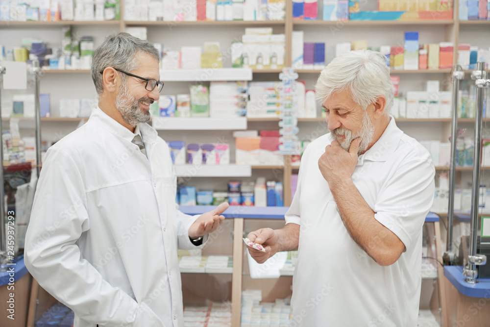 Pensioner and pharmacist consulting in drugstore.
