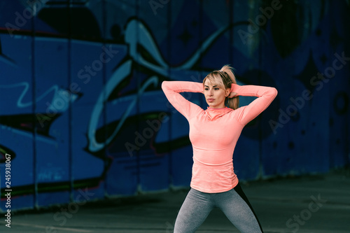 Dedicated blonde sporty beautiful woman with serious face exercising outdoors.