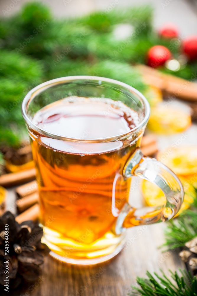 Hot tea in glass cup with atmospheric winter decorations. Selective focus. Shallow depth of field. Hot tea in glass cup with atmospheric winter decorations. Selective focus. Shallow depth of field.