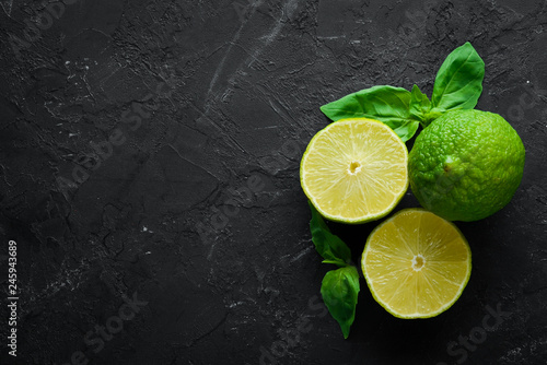 Fresh green limes. Lemon. On a black background. Top view. Free copy space.