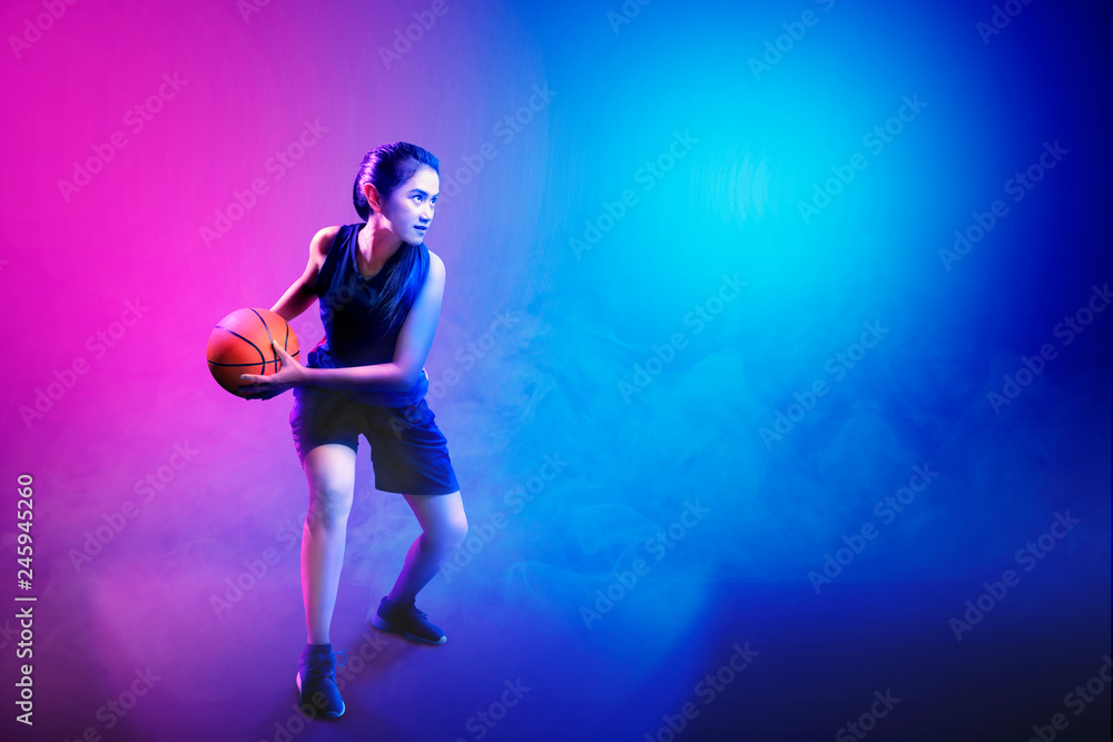 Young asian woman playing basketball