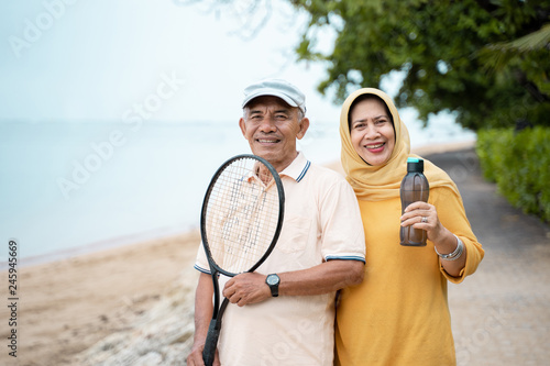 senior asian man and woman smiling with racket tennis © Odua Images