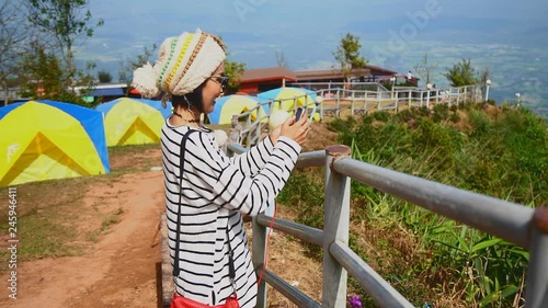 Woman taking photography with smartphone for sharing photo of landscape.