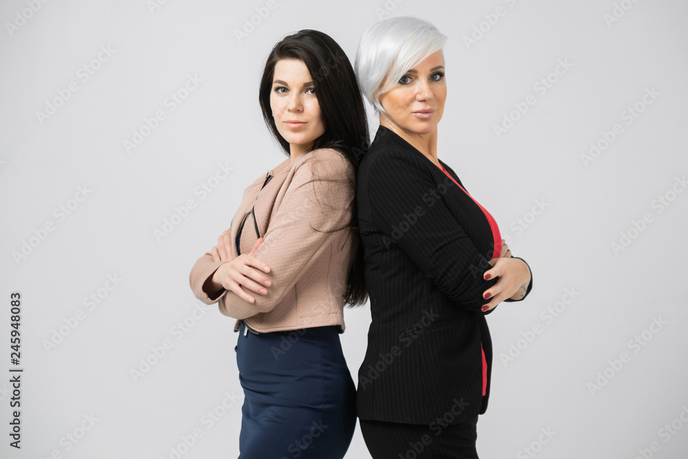 Portrait of waist-deep Two young girls standing back-to-back isolated on white background Portrait of waist-deep Two young girls standing back-to-back isolated on white background