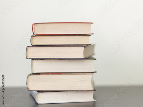 a stack of different books in a thick cover on the table