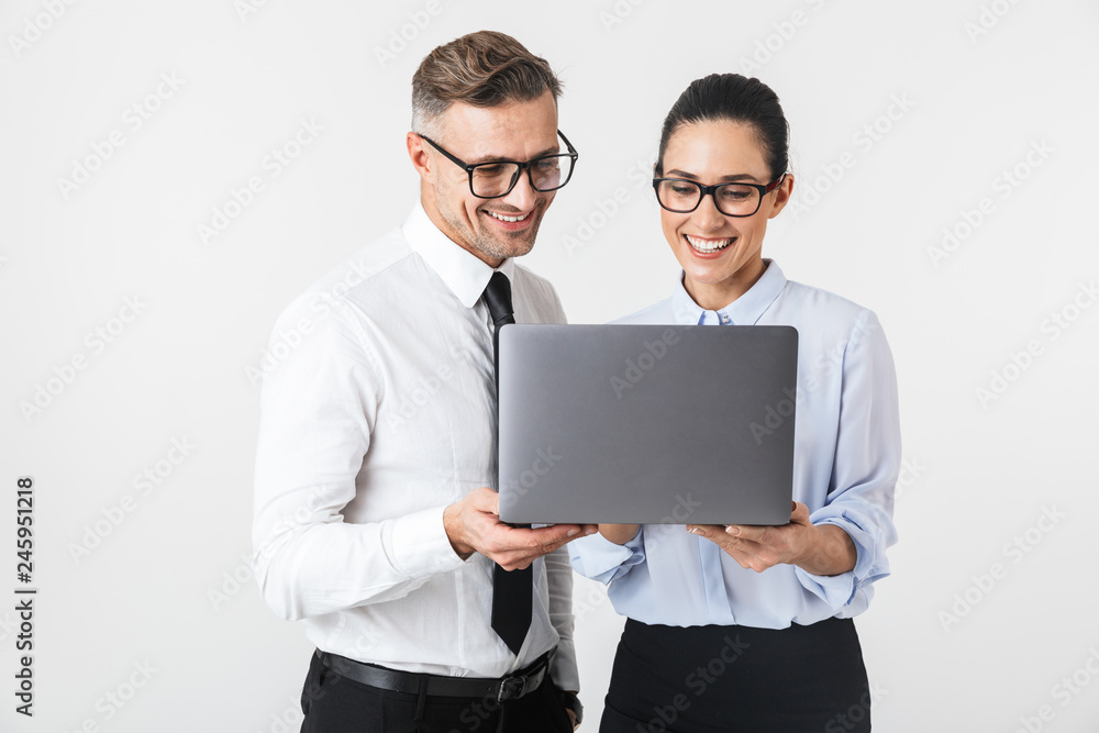 Business colleagues couple isolated over white wall background using laptop computer. Business colleagues couple isolated over white wall background using laptop computer.