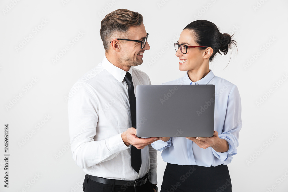 Business colleagues couple isolated over white wall background using laptop computer. Business colleagues couple isolated over white wall background using laptop computer.