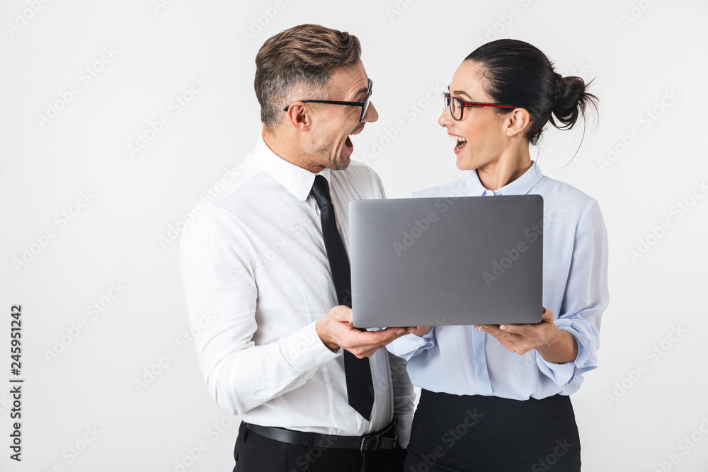 Business colleagues couple isolated over white wall background using laptop computer. Business colleagues couple isolated over white wall background using laptop computer.