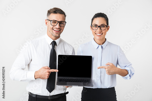 Business colleagues couple isolated over white wall background using laptop computer.