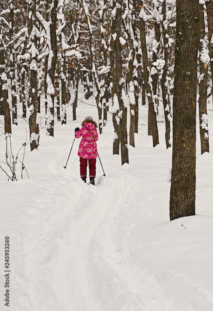 kid skiing in winter forest