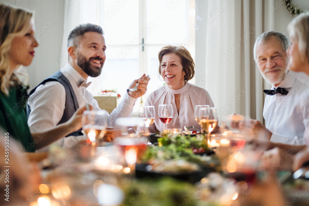 A big family sitting at a table on a indoor birthday party, eating. A big family sitting at a table on a indoor birthday party, eating.