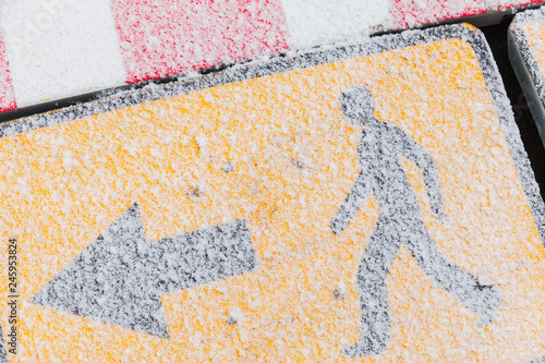 Yellow road sign with snow