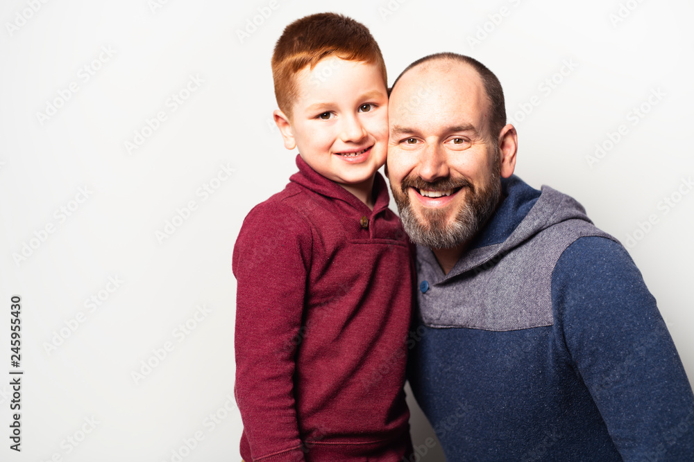 cheerful redhead father and son and smiling at camera isolated on white cheerful redhead father and son and smiling at camera isolated on white