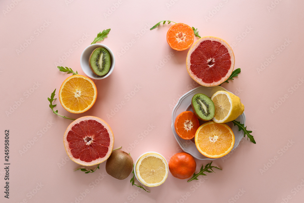 Tropical fruits frame from orange, lemon, tangerine and kiwi on pink paper background. Healthy food concept. flat lay. Top view Tropical fruits frame from orange, lemon, tangerine and kiwi on pink paper background. Healthy food concept. flat lay. Top view