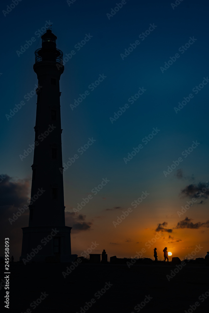 Aruba ,California Lighthouse and people in silhouette at sunrise