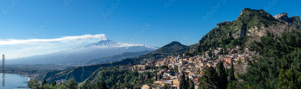 City of Taormina in Sicily. In background smoking volcano Etna