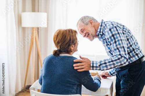 A senior couple sitting at the table at home  having breakfast.