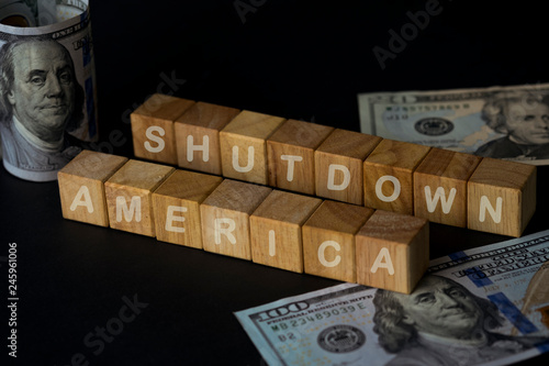 America shutdown wording on wooden cubes and US dollar banknote on black background. For government of United States of America shutdown concept. Image
