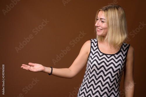 Beautiful businesswoman with short blond hair showing copyspace