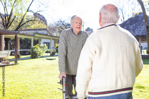 Seniors smiling and talking in nursing home garden
