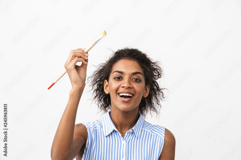 Beautiful young african woman atrist holding a paint brush Beautiful young african woman atrist holding a paint brush