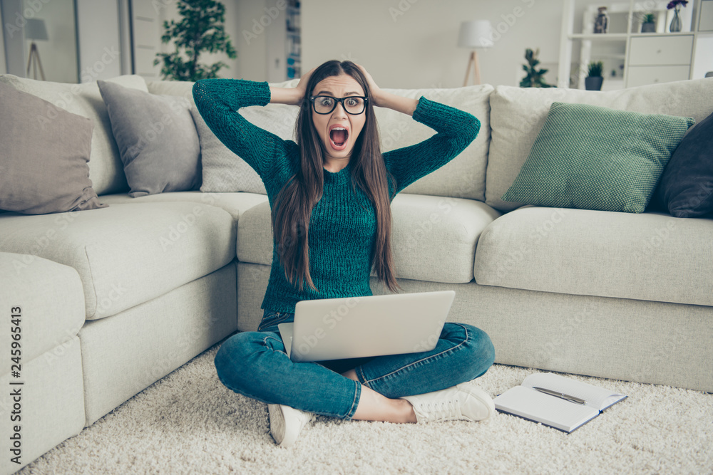Obraz premium Amazed surprised funny funky screaming student holding laptop on legs sitting on floor touching head looking at camera