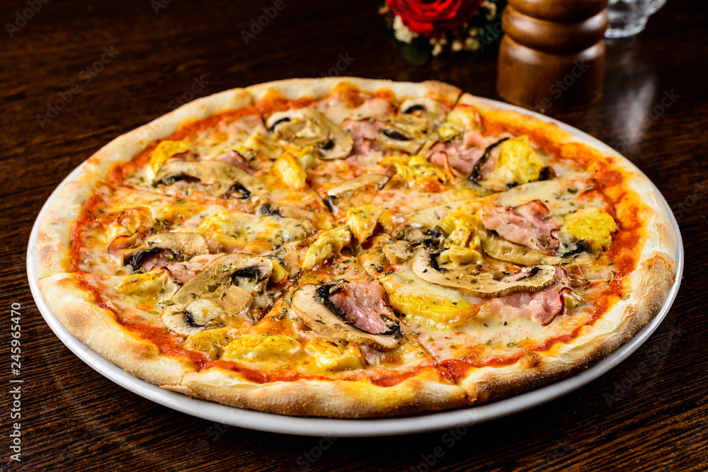 Tasty warm pizza with bacon, mushrooms, cheese and onion on the table, close-up Tasty warm pizza with bacon, mushrooms, cheese and onion on the table, close-up