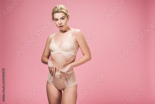 elegant girl posing in lingerie, isolated on pink