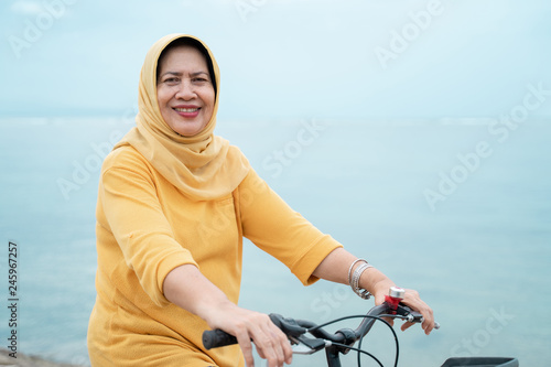 happy senior muslim female riding a bicycle