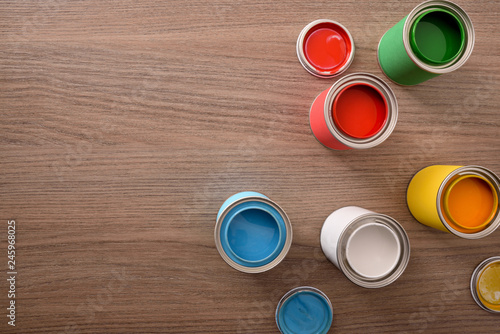Five open paint cans and their covers on table top