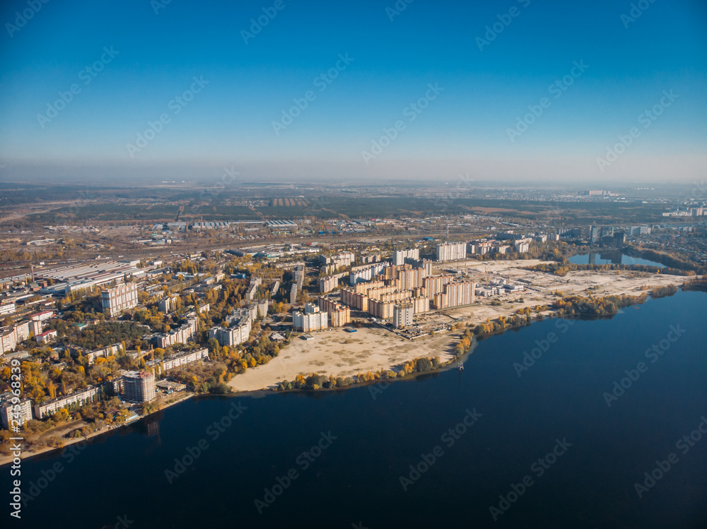 Aerial view of city with buildings on bay of big river with blue water, drone photo