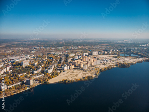 Aerial view of city with buildings on bay of big river with blue water, drone photo