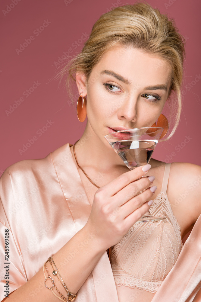 attractive young woman in silk robe holding cocktail glass, isolated on pink attractive young woman in silk robe holding cocktail glass, isolated on pink