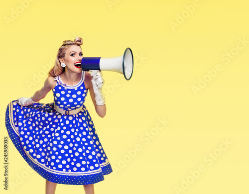 happy woman holding megaphone, dressed in pin-up style dress