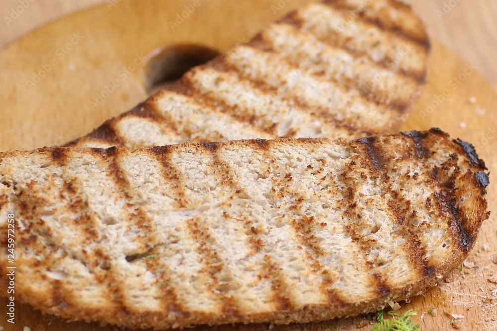 two grilled bread toast slices with shreded dill on kitchen board two grilled bread toast slices with shreded dill on kitchen board