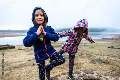 Fotografie Twin girls standing on remains of ancient roman water well.