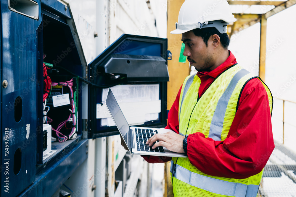 Engineer used laptop and monitoring the temperature of container box. Engineer used laptop and monitoring the temperature of container box.